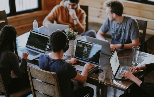 Team of developers collaborating at wooden table