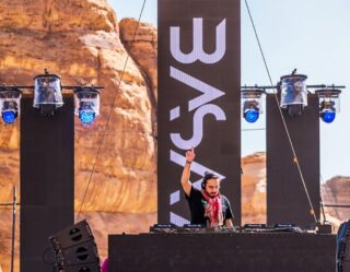 DJ performing at outdoor desert music festival stage