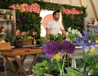 Florist arranging flowers in shop with botanical backdrop