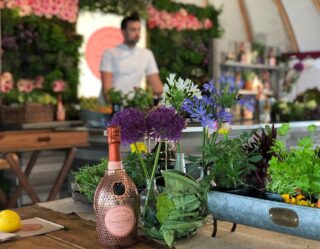Rosé bottle and fresh flowers on outdoor table