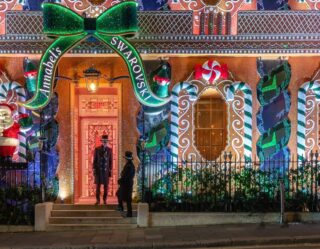 Elaborately decorated gingerbread house facade at night
