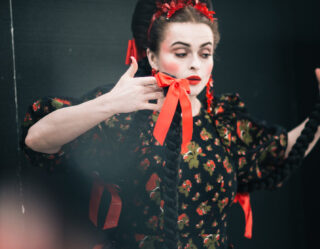 Woman in floral dress with red ribbon bow
