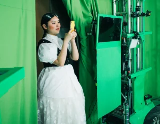 Woman in white dress on green screen set