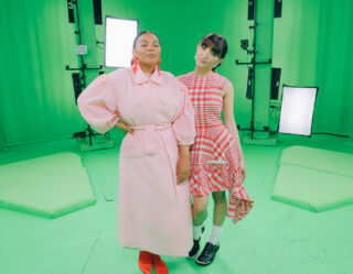 Two people posing in green studio with professional lighting