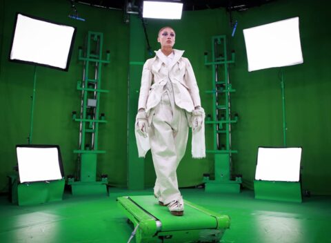 Model in white outfit on green screen set