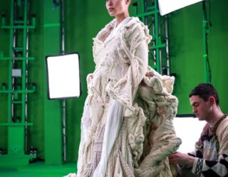 Actress in elaborate costume on green screen set