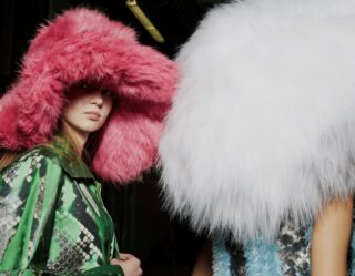 Two models wearing oversized fluffy fur hats