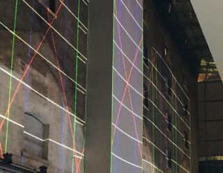 Illuminated grid projection on historic building facade