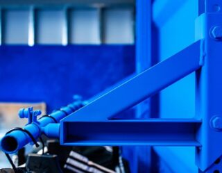Blue industrial pipe with valve on structural frame