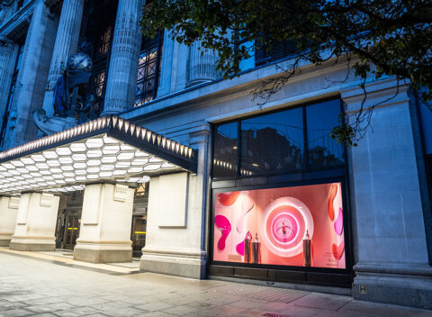 Luxury retail storefront with illuminated entrance canopy at dusk