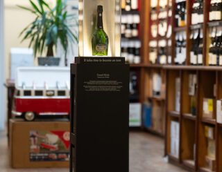 Wine bottle display on black pedestal in store