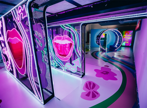 Neon-lit interactive art installation with glowing pink lips